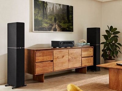 Floor standing speakers and an amplifier in a living room setting.